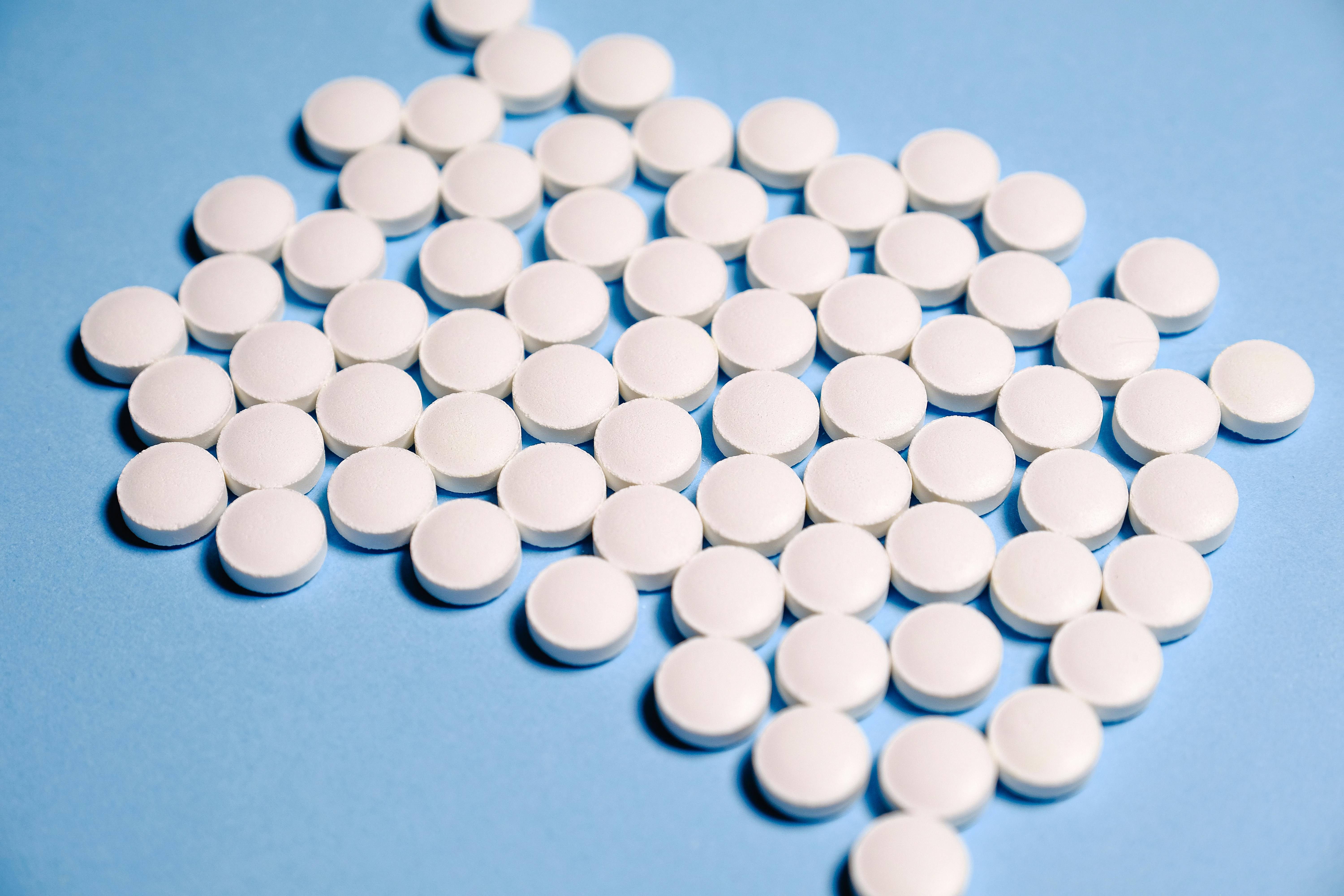 White opioid pills on a blue background